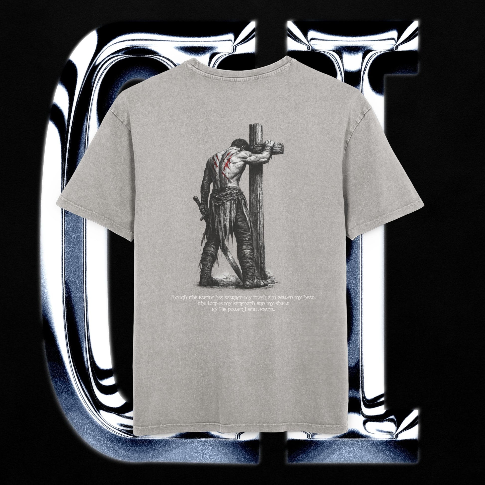Gray t-shirt with a graphic design of a person on a cross and text, displayed against a reflective silver background.